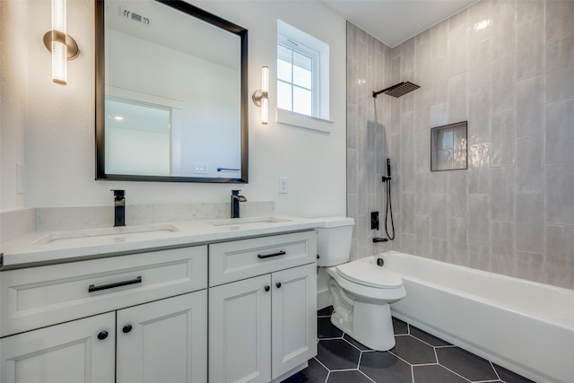 full bathroom featuring tile patterned flooring, vanity, tiled shower / bath combo, and toilet