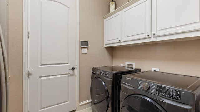 washroom featuring cabinets and independent washer and dryer