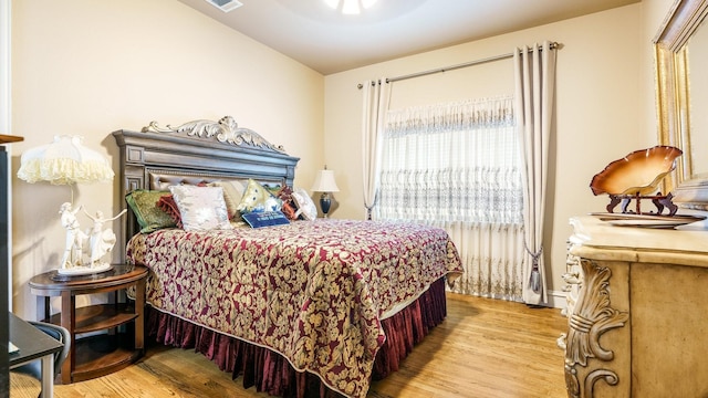 bedroom featuring light hardwood / wood-style flooring and lofted ceiling