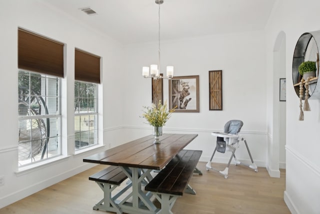 dining space with a notable chandelier and light wood-type flooring