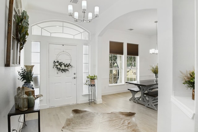 foyer with crown molding and light hardwood / wood-style flooring