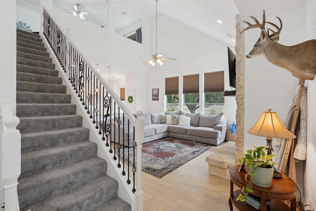 living room featuring hardwood / wood-style floors, high vaulted ceiling, and ceiling fan