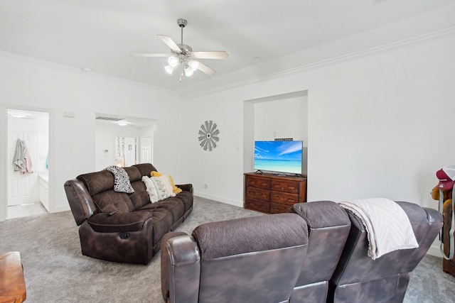 living room with ceiling fan, ornamental molding, and light carpet