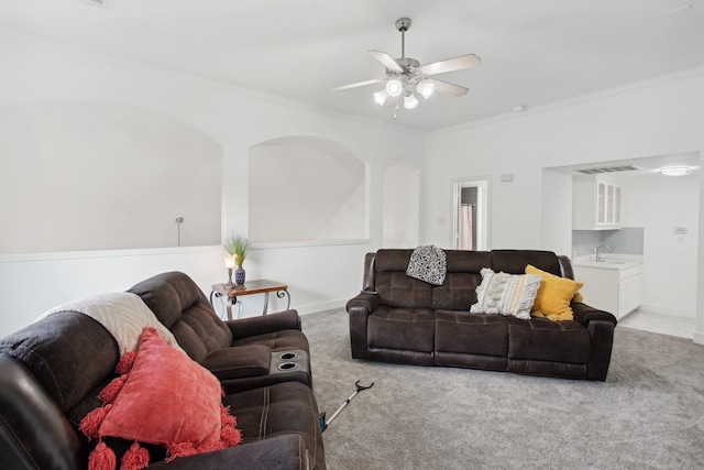 carpeted living room featuring crown molding, sink, and ceiling fan