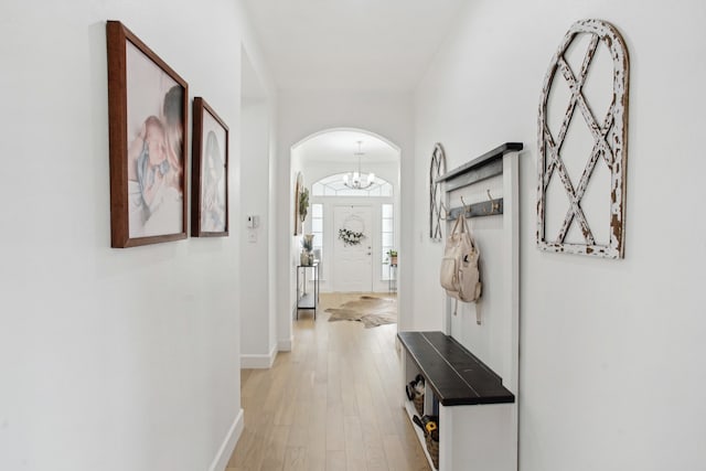 corridor featuring a chandelier and light hardwood / wood-style flooring