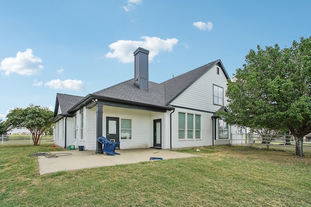 back of property with a yard and a patio