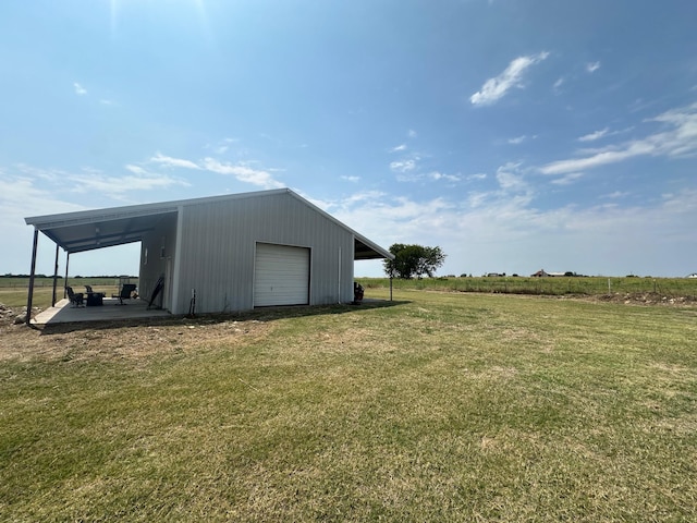 view of outdoor structure featuring a carport, a garage, and a yard