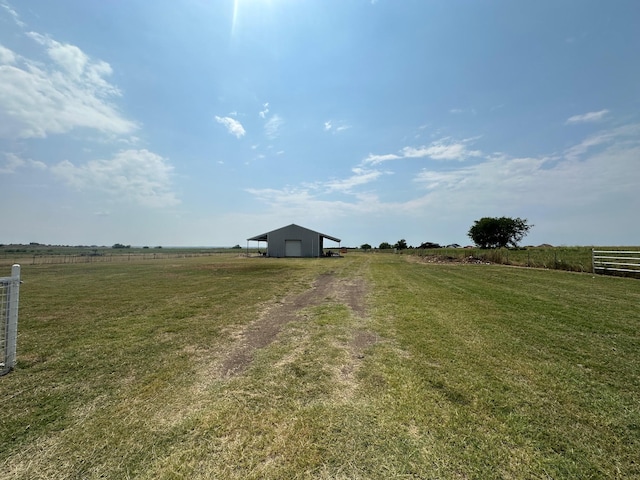 view of yard with a rural view and an outbuilding