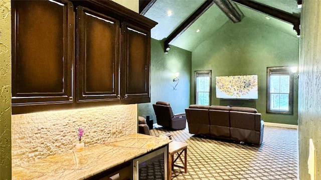 interior space featuring beamed ceiling, dark brown cabinets, high vaulted ceiling, and beverage cooler