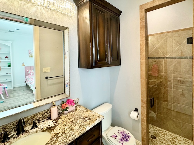 bathroom featuring hardwood / wood-style flooring, vanity, toilet, and an enclosed shower