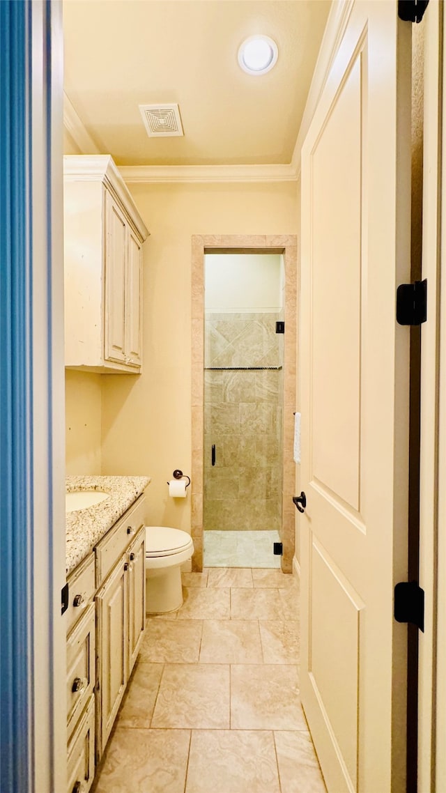 bathroom featuring tiled shower, toilet, crown molding, and vanity