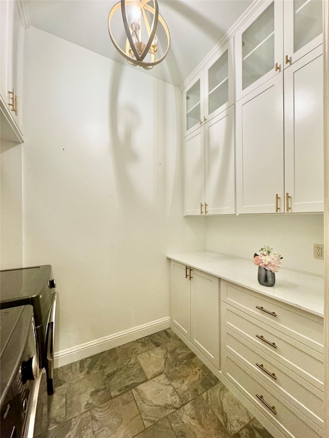 laundry area with cabinets and a notable chandelier