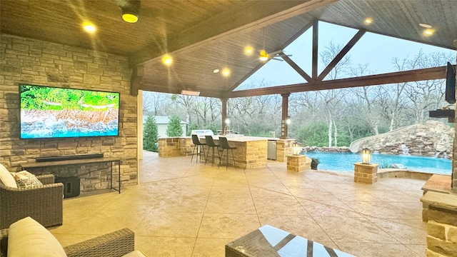 patio terrace at dusk featuring pool water feature and exterior bar