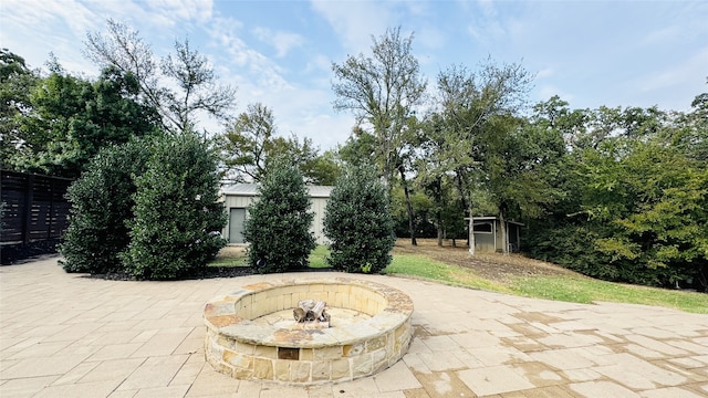 view of patio with a shed and an outdoor fire pit