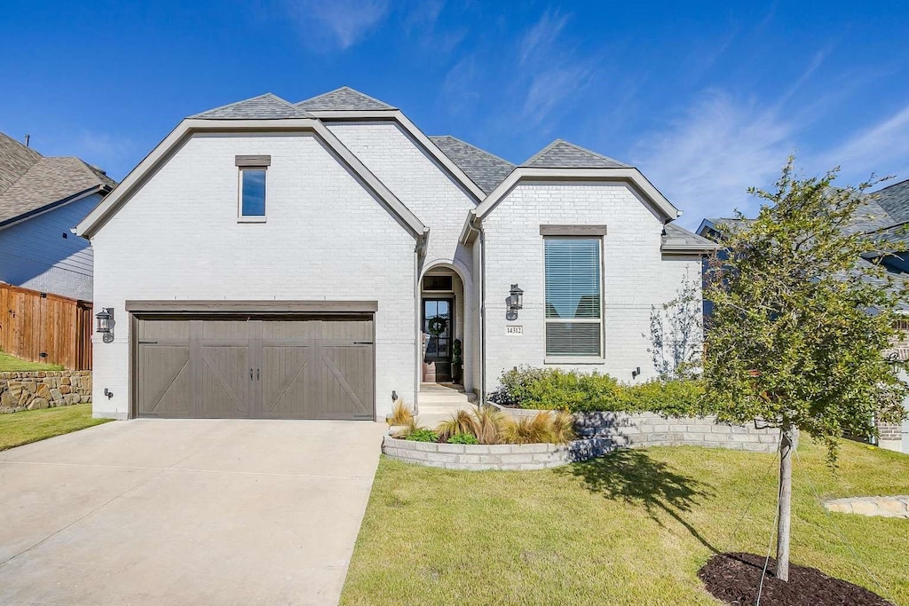 view of front of property with a garage and a front lawn