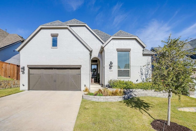 view of front of property with a garage and a front lawn