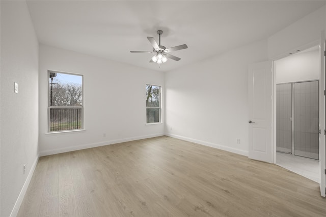 spare room with a ceiling fan, baseboards, and light wood-type flooring