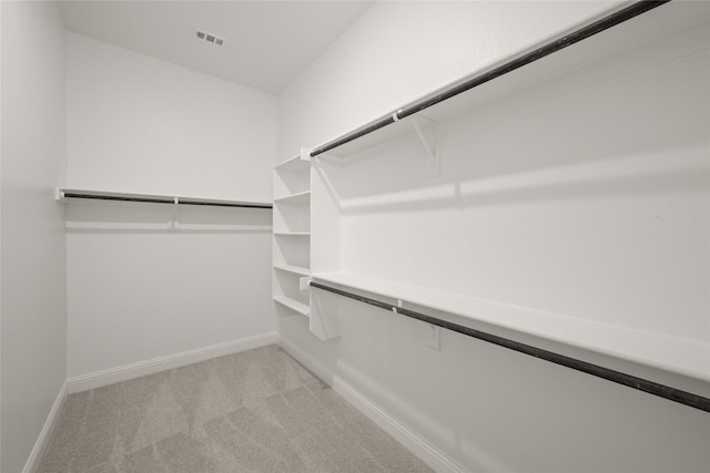 spacious closet featuring visible vents and light carpet