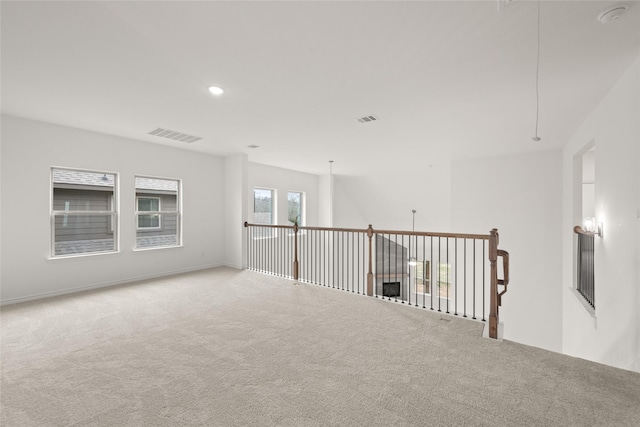 unfurnished room featuring light carpet, visible vents, recessed lighting, and attic access