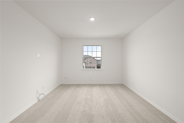 unfurnished room with baseboards and light carpet