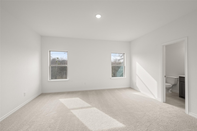 unfurnished room with recessed lighting, carpet flooring, a healthy amount of sunlight, and baseboards