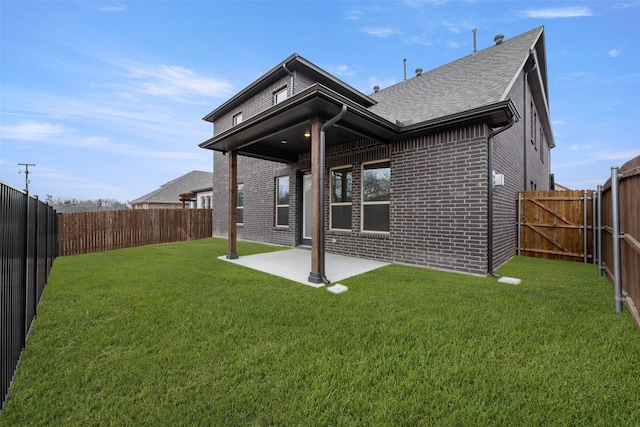 rear view of house featuring a patio, a yard, and brick siding