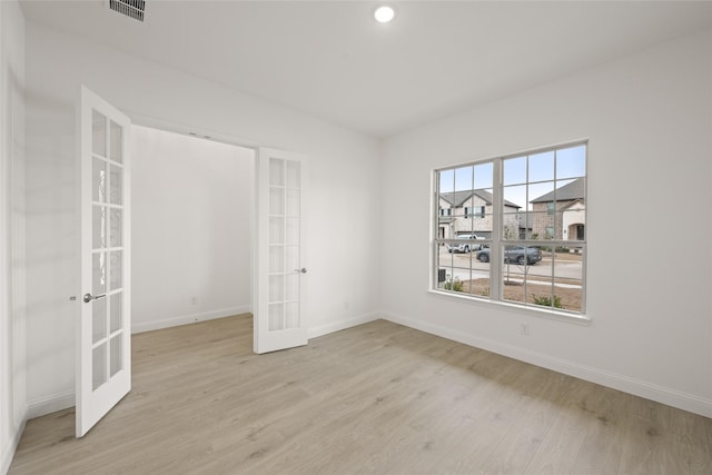 interior space featuring french doors, baseboards, visible vents, and light wood finished floors