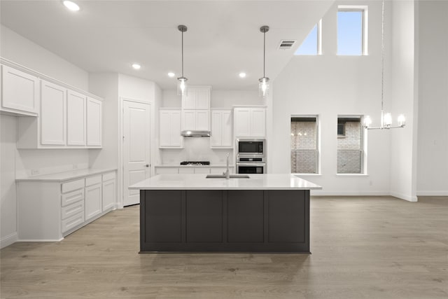 kitchen featuring visible vents, light countertops, appliances with stainless steel finishes, white cabinetry, and a sink