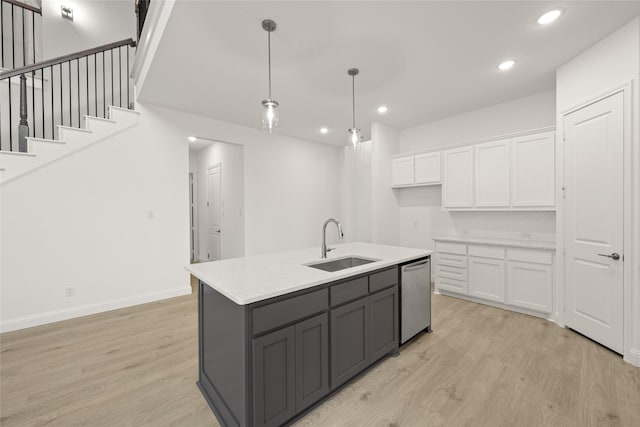 kitchen featuring a sink, light wood-style floors, dishwasher, and white cabinets