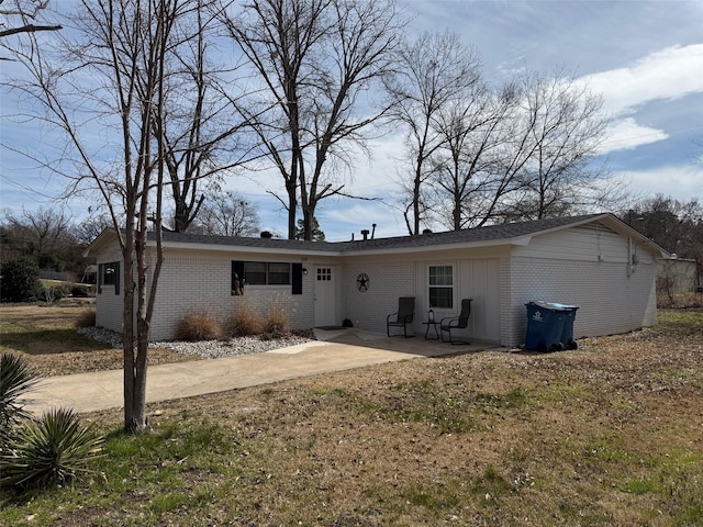 rear view of house with a patio and brick siding