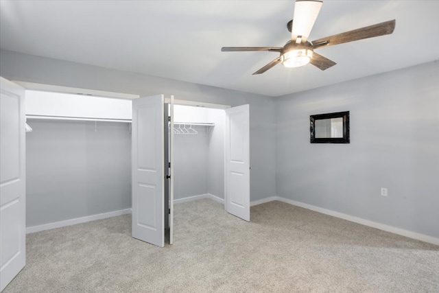 unfurnished bedroom featuring ceiling fan, a closet, and light carpet