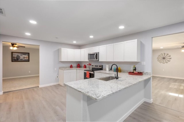 kitchen featuring sink, white cabinetry, kitchen peninsula, stainless steel appliances, and light hardwood / wood-style floors