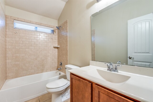 full bathroom featuring vanity, tiled shower / bath combo, tile patterned flooring, toilet, and lofted ceiling