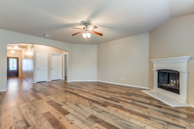 unfurnished living room featuring hardwood / wood-style floors, ceiling fan, and lofted ceiling