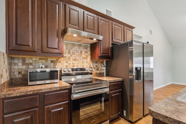 kitchen featuring stainless steel appliances, range hood, backsplash, light hardwood / wood-style floors, and dark brown cabinets