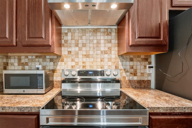 kitchen with backsplash, stainless steel appliances, light stone counters, and range hood