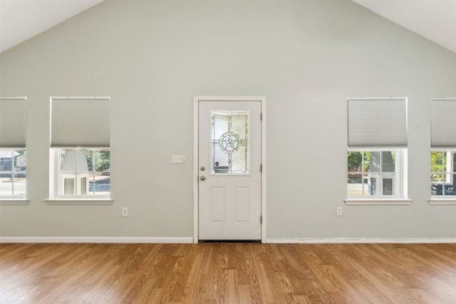 entryway with light wood-type flooring and high vaulted ceiling