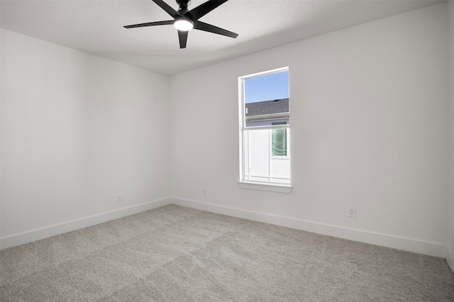 empty room with ceiling fan and light carpet