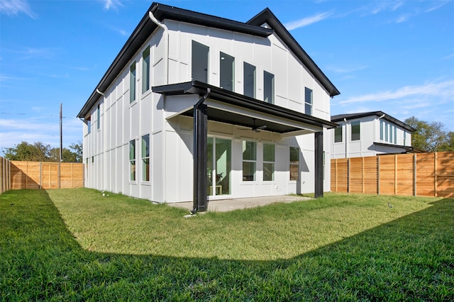 rear view of property featuring a patio area, ceiling fan, and a lawn