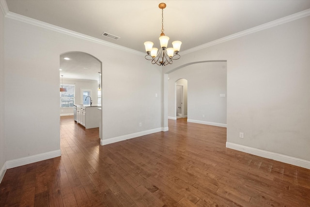unfurnished room with an inviting chandelier, dark wood-type flooring, a sink, arched walkways, and visible vents
