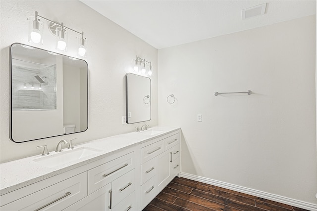 bathroom with hardwood / wood-style floors, vanity, and toilet