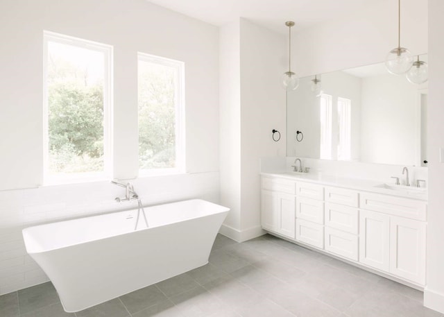 bathroom with tile patterned floors, a bathtub, tile walls, and vanity