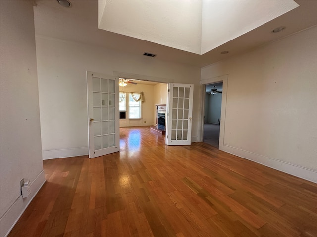 empty room with french doors and hardwood / wood-style floors