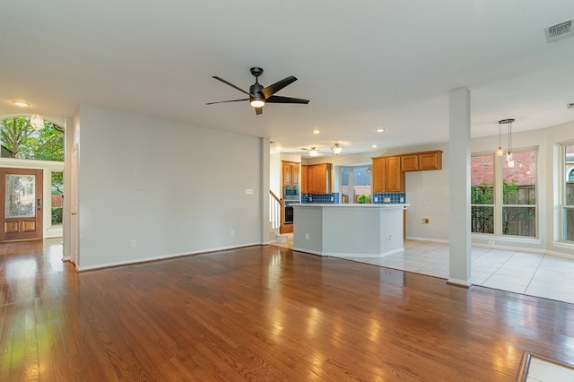 unfurnished living room featuring ceiling fan and light hardwood / wood-style floors