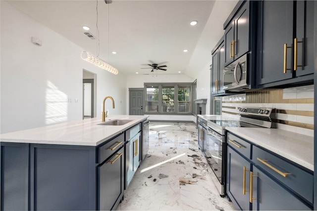 kitchen featuring appliances with stainless steel finishes, ceiling fan, sink, a center island with sink, and hanging light fixtures