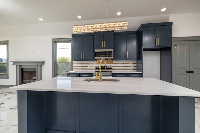 kitchen featuring light stone countertops, sink, a spacious island, and appliances with stainless steel finishes