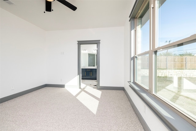 carpeted empty room with ceiling fan and a healthy amount of sunlight