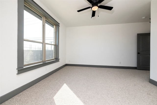 unfurnished room with ceiling fan and carpet