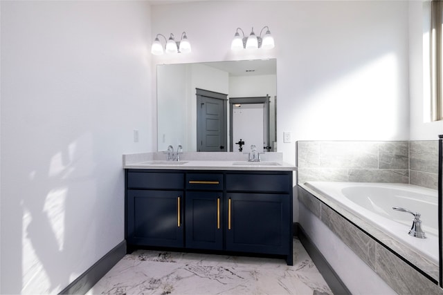 bathroom featuring tiled tub and vanity