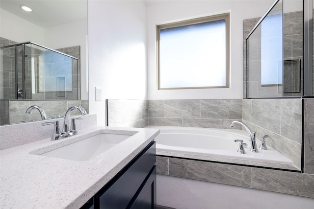 bathroom featuring separate shower and tub and vanity